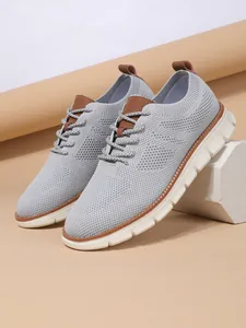 Detail of grey breathable knit sneaker with brown leather accents and white rubber sole