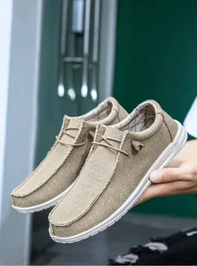 Dettaglio della trama in tela beige e lacci decorativi di questi mocassini da uomo