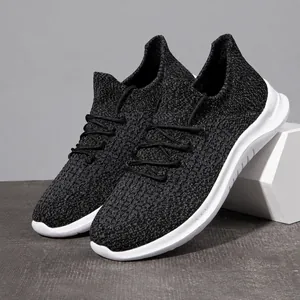 Detail of black breathable fly-knit men sneakers with streamlined white cushioned sole