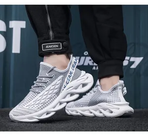 Dettaglio delle scarpe da corsa uomo bianco e grigio con suola a lama e tessuto mesh