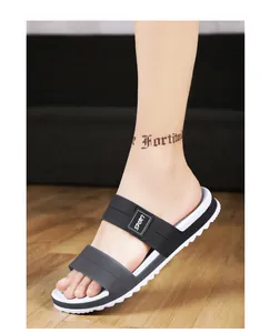 Detail view of black and white EVA sport slippers with durable anti-slip soles on wood floor
