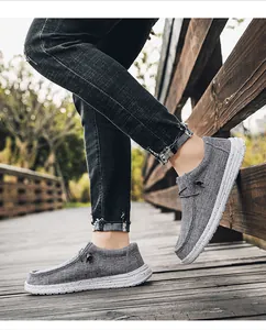 Close-up of gray canvas loafers with woven texture and speckled anti-slip sole on wood