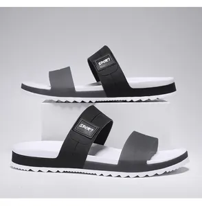 Detailed side view of black and white sport slippers showing anti-slip jagged sole and straps