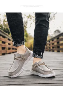 Detail of light gray canvas loafers with splash-ink sole shown on wooden boardwalk