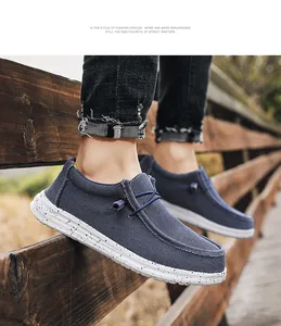Close-up of navy canvas loafers with breathable fabric and speckled soles on wooden fence
