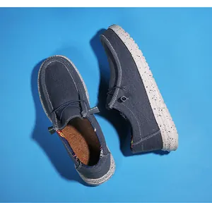 Detail view of navy canvas loafers featuring a speckled rubber sole and exquisite side label