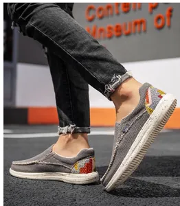 Détail de chaussure en toile grise sans lacets avec broderie géométrique au talon