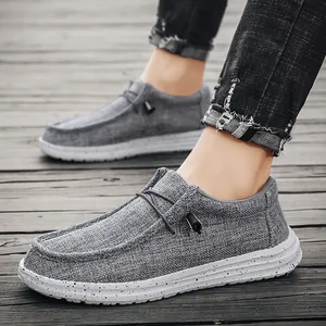 Men's dark gray casual canvas loafers with speckled white soles on wooden floor