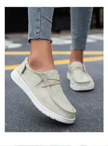 Detalle de mocasines de lona verde claro en el pie con suelas de goma blanca antideslizantes