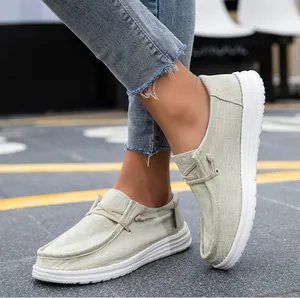 Primer plano de mocasines de lona verde claro para mujer con suelas de goma blancas