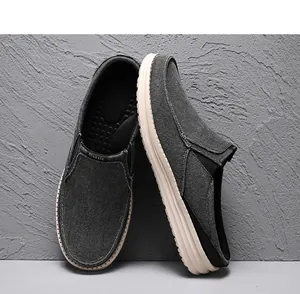 Detail of dark grey canvas loafers with thick rubber soles and Classic text design