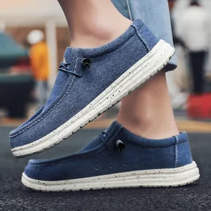 Detalle de mocasines de lona azul oscuro con cordón y suela gruesa blanca moteada