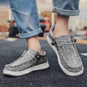 Primer plano de mocasines de lona gris con suela blanca moteada y cordones elásticos