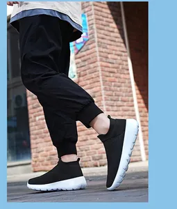 Close-up of black breathable knit slip-on sneakers with thick white foam sole on a model
