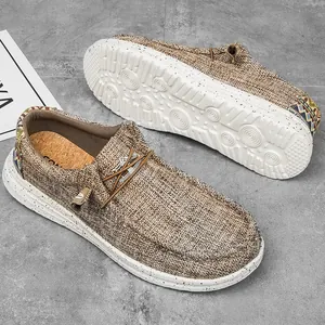 Detalle de mocasines de lona marrón con correa étnica y suela de goma con motas negras
