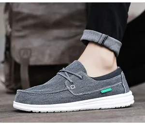 Detail van grijze canvas instapschoenen met dikke witte rubberen zolen en klassiek label