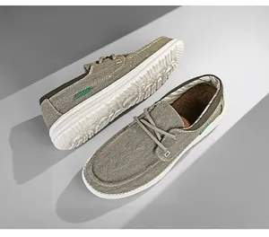 Detail van grijsgroene canvas loafers met witte rubberen antislipzolen en klassieke labels