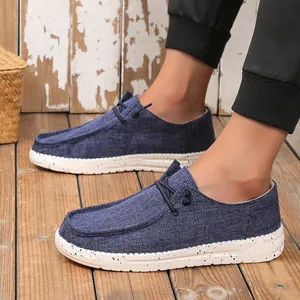 Close-up of blue canvas loafers for men with white speckled soles on wooden flooring