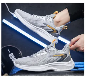 Detailweergave van de grijze mesh hardloopschoenen met oranje accenten en dikke witte zool