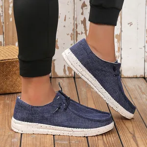 Men's denim blue canvas loafers featuring a white speckled sole and slip-on style