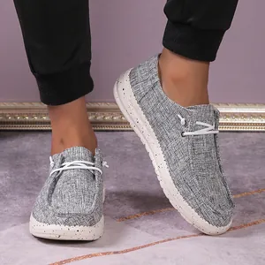 On-foot view of grey canvas loafers with white speckled rubber soles and elastic laces