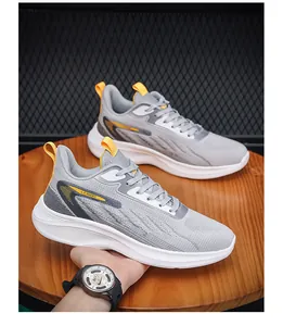 Detail van grijze en gele hardloopschoenen voor heren met ademend mesh en witte zolen