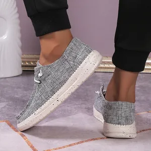 Men's grey canvas loafers showing the thick speckled rubber sole and fabric texture