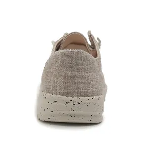 Detailed rear view of beige canvas loafers featuring speckled thick soles and woven texture