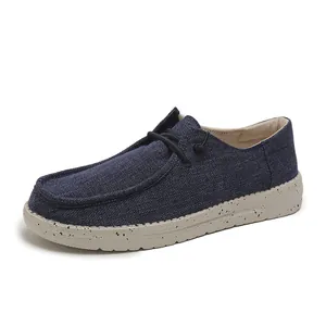 Detail of dark blue canvas loafers with speckled soles and classic moccasin toe design