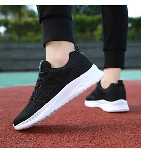 Dettaglio macro della tomaia in mesh traspirante sulle scarpe da corsa nere da uomo