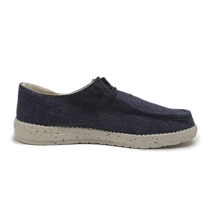 Side view detail of men's blue canvas loafers with speckled gray rubber outsole texture