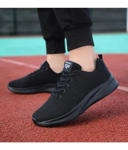 Dettaglio di scarpe da corsa nere in mesh traspirante con suole antiscivolo su campo