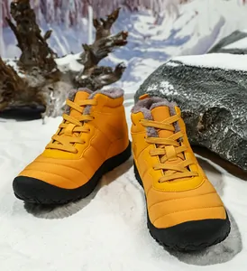 Detail of high-top winter snow boot with orange quilted fabric and thick warm lining