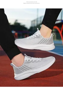Scarpe da corsa grigie traspiranti con suola bianca spessa indossate su pista atletica