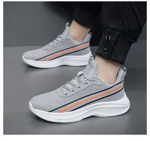 Gedetailleerd zijaanzicht van grijze mesh sneakers met oranje strepen en witte zolen