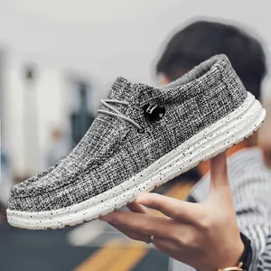 Grijze canvas herenloafers met slip-on design en zwarte verfspatten op de witte dikke zolen