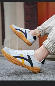 Detalle de la zapatilla de malla blanca con ante gris y suela de goma antideslizante