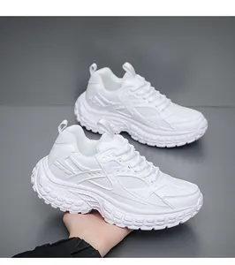 Detailed view of white chunky sneakers featuring mesh panels and textured platform soles