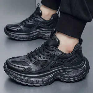 Men's all-black chunky dad sneakers with breathable mesh and leather paneling worn on feet