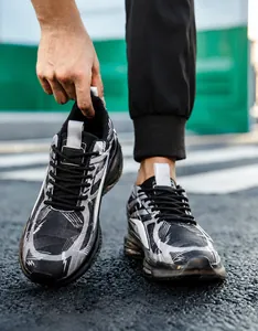 Detail of chunky sneakers featuring black and white graffiti pattern and cushioned sole