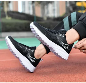Vue en extérieur de baskets de sport noir et blanc avec semelles épaisses sur piste de course