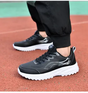 Vue latérale de baskets en cuir noir pour hommes avec semelles blanches sur piste