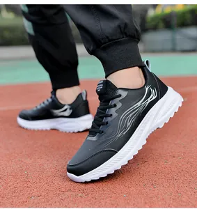 Vue détaillée de baskets légères en cuir noir avec motif flamme grise sur une piste rouge