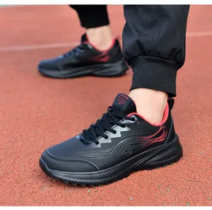 Gros plan de baskets en similicuir noir avec motifs à vagues rouges sur une piste