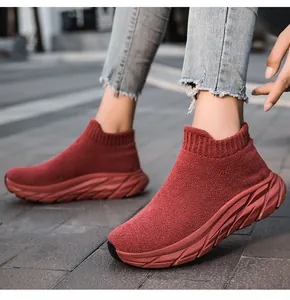 Vista macro de zapatillas de punto rojo oscuro con suela gruesa en suelo de piedra