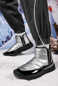Close-up of metallic silver snow boot with side zipper and quilted thermal texture