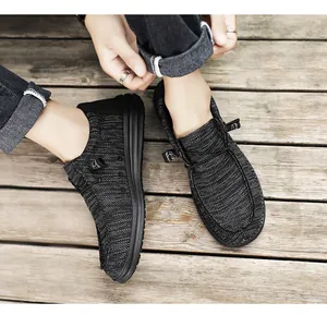 Vista superior de mocasines de punto gris transpirables para hombre en suelo de madera