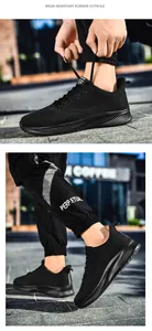 Close-up of durable wear-resistant rubber outsole and breathable mesh fabric on black sneakers