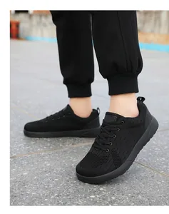 Outdoor shot of men's all-black mesh running shoes with breathable fabric and laces