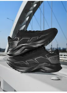 Outdoor close-up of breathable black mesh running sneakers with chunky cushioned soles